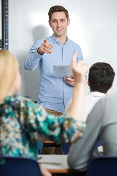 Teacher Answering Pupils Question In Classroom