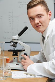 Portrait Of Pupil Using Microscope In Science Lesson