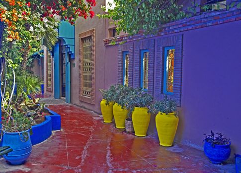 A view of a Colourful terrace with yellow pottery containers in a decorative  garden in Marrakech 