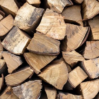 Background of dry chopped firewood logs in a pile