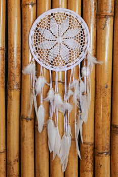 White crocheted dreamcatcher, an Indian amulet that protects the sleeper from evil spirits and diseases. Soft focus. Closeup.