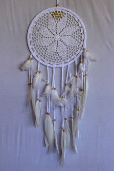 White crocheted dreamcatcher, an Indian amulet that protects the sleeper from evil spirits and diseases. Soft focus. Closeup.