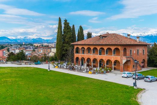 Udine - March 2016, Italy:  Panoramic view of the city, old historical restaurant building and the mountains to the north from Udine Castle