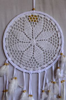 White crocheted dreamcatcher, an Indian amulet that protects the sleeper from evil spirits and diseases. Soft focus. Closeup.