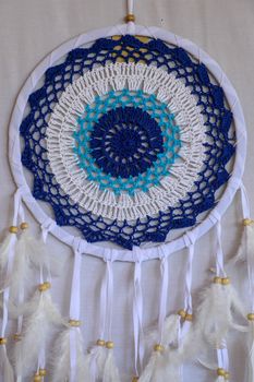 Blue Dreamcatcher with feathers and beads isolated on a white background.