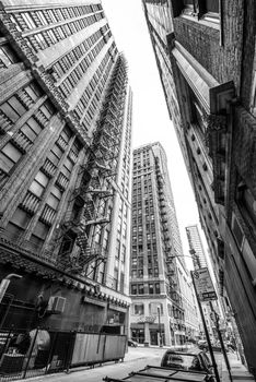 Chicago - March 2017, USA: View through narrow street between skyscrapers in downtown Chicago. Black and white photography