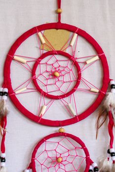 Pink ash crochet doily dream catcher close up on dark gray textured background. Texture of concrete, copy space for text. White background.