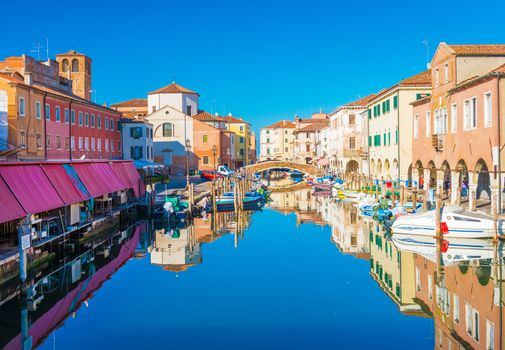 Chioggia - September 2016, Veneto, Italy: Cityscape of Chioggia historic city center. Canal Vena with boats lying on water and colored houses in traditional architectural style