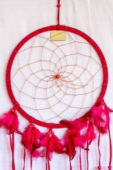 Pink ash crochet doily dream catcher close up on dark gray textured background. Texture of concrete, copy space for text. White background.