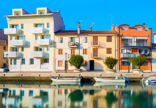 Grado - December 2015, Italy: Colored houses and boats on the water, one of the canals in Grado