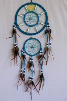 Blue Dreamcatcher with feathers and beads isolated on a white background.