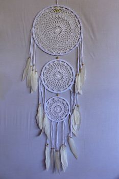 White crocheted dreamcatcher, an Indian amulet that protects the sleeper from evil spirits and diseases. Soft focus. Closeup.