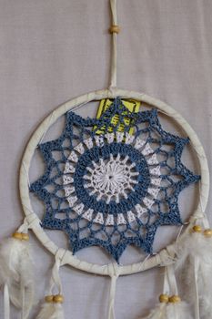 Blue Dreamcatcher with feathers and beads isolated on a white background.