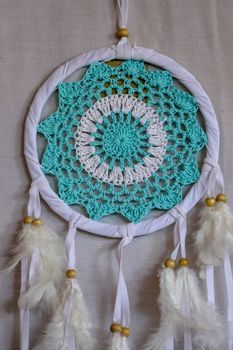 Dream catcher with blue turquoise threads closeup in the interior.