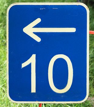 The number ten on a blue metal plate with a white arrow pointing to the left, germany