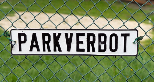 Shield with the German inscription "No Parking" on a wire mesh fence, germany