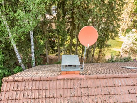 Checking the satellite dish of a house with a drone, aerial photograph, from the roof of a detached house, air intake