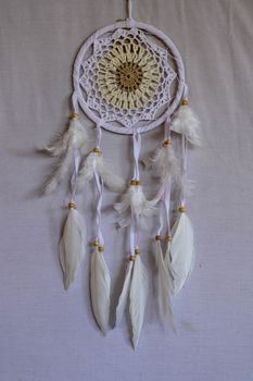 White crocheted dreamcatcher, an Indian amulet that protects the sleeper from evil spirits and diseases. Soft focus. Closeup.