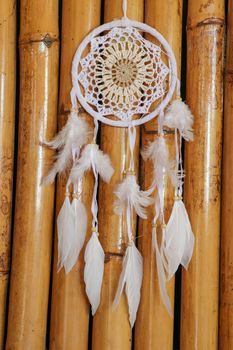 White crocheted dreamcatcher, an Indian amulet that protects the sleeper from evil spirits and diseases. Soft focus. Closeup.