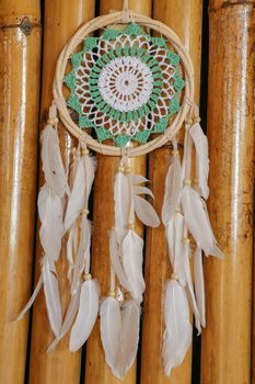 Beautiful green dream catcher on wodden background.