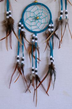 Blue Dreamcatcher with feathers and beads isolated on a white background.