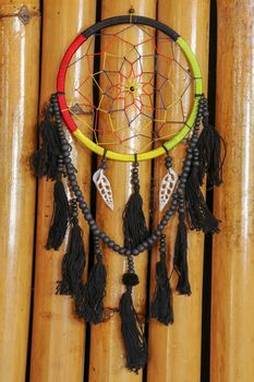 Beautiful multicolored handmade dreamcatcher with sea shells on natural bamboo background.