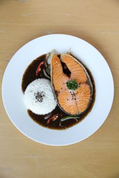 salmon black paper with rice on wood background