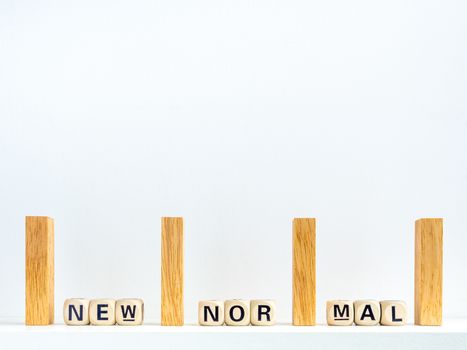 Social Distancing concept. Row of wooden dominoes with distance space and New Normal, words on wooden alphabet cube on white background with copy space.