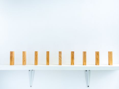 Social Distancing concept. Row of wooden dominoes with distance space on shelf on white background.