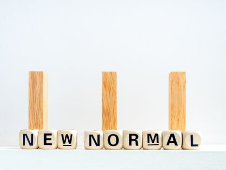 Social Distancing concept. Row of wooden dominoes with distance space and New Normal, words on wooden alphabet cube on white background.