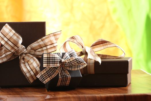 Presents on a table with a bow. Background space for copy. For Christmas, birthday or other holiday cards