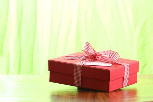 Presents on a table with a bow. Background space for copy. For Christmas, birthday or other holiday cards