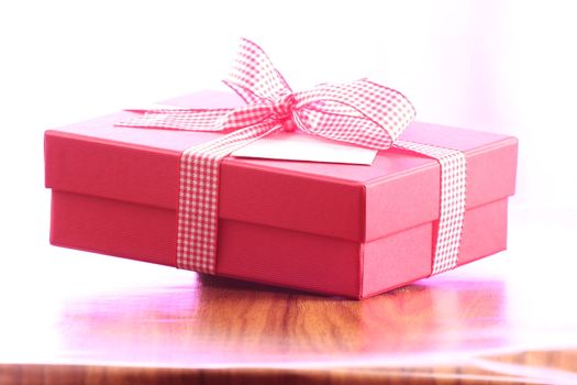 Presents on a table with a bow. Background space for copy. For Christmas, birthday or other holiday cards