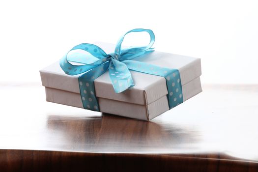 Presents on a table with a bow. Background space for copy. For Christmas, birthday or other holiday cards