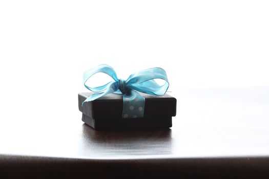 Presents on a table with a bow. Background space for copy. For Christmas, birthday or other holiday cards