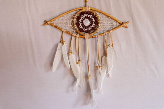 god eye of providence dreamcatcher with white feathers on a white background.