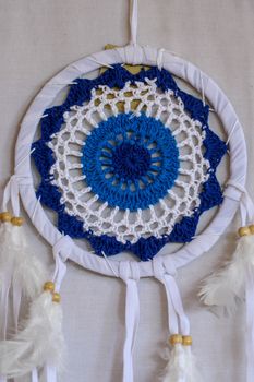 Blue Dreamcatcher with feathers and beads isolated on a white background.