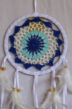 Blue Dreamcatcher with feathers and beads isolated on a white background.