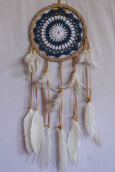 Blue Dreamcatcher with feathers and beads isolated on a white background.