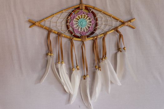 god eye of providence dreamcatcher with white feathers on a white background.