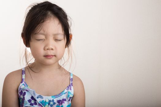 Little girl does mediation alone on with white background.