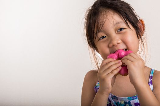 Little girl is eating her donut with happiness.