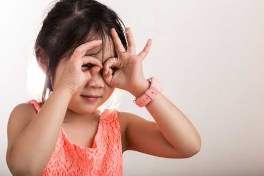 Little girl uses her hands as imaginary binoculars background.