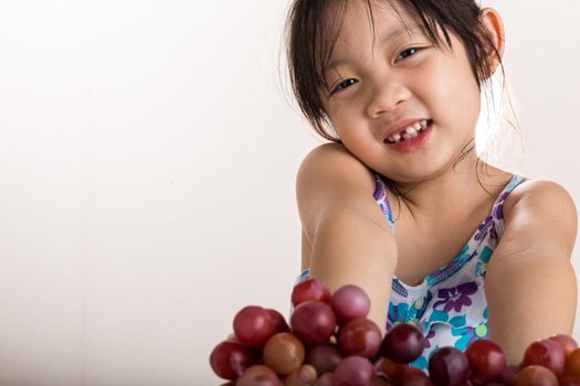 Child is holding grapes in her hands background.