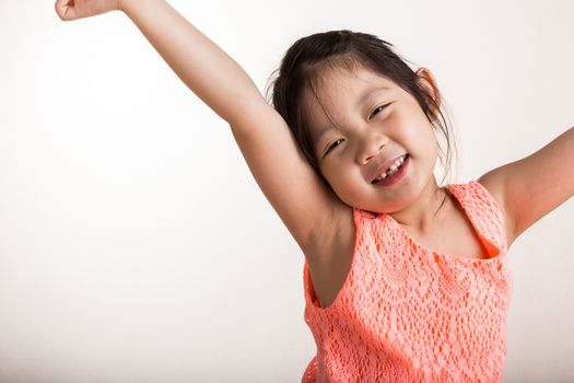 Little girl stretches in the morning after woke up.