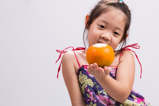 Child is holding orange in her hand background.