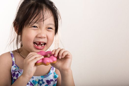 Little girl is eating her donut with happiness.