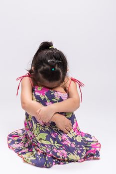 Sad little girl on isolated white background.