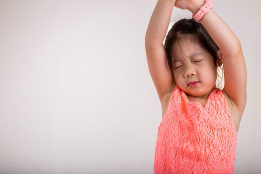 Little girl stretches in the morning after woke up.