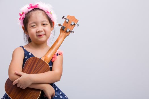 Little girl with her ukulele, string music instrument.